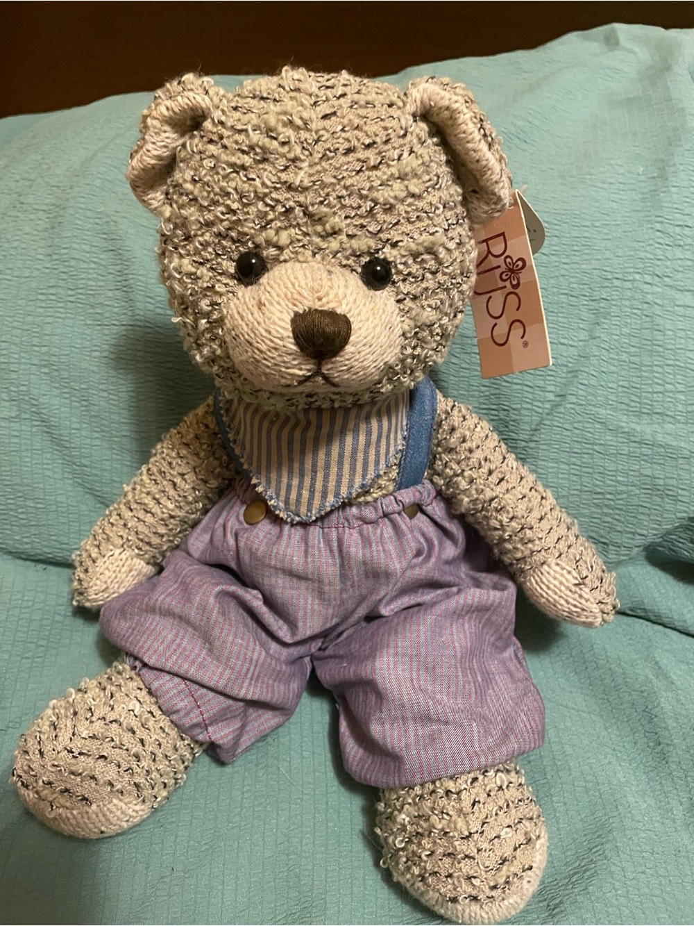 This is a 1990s Russ Berrie plush teddy bear wearing striped overalls. HARRISON